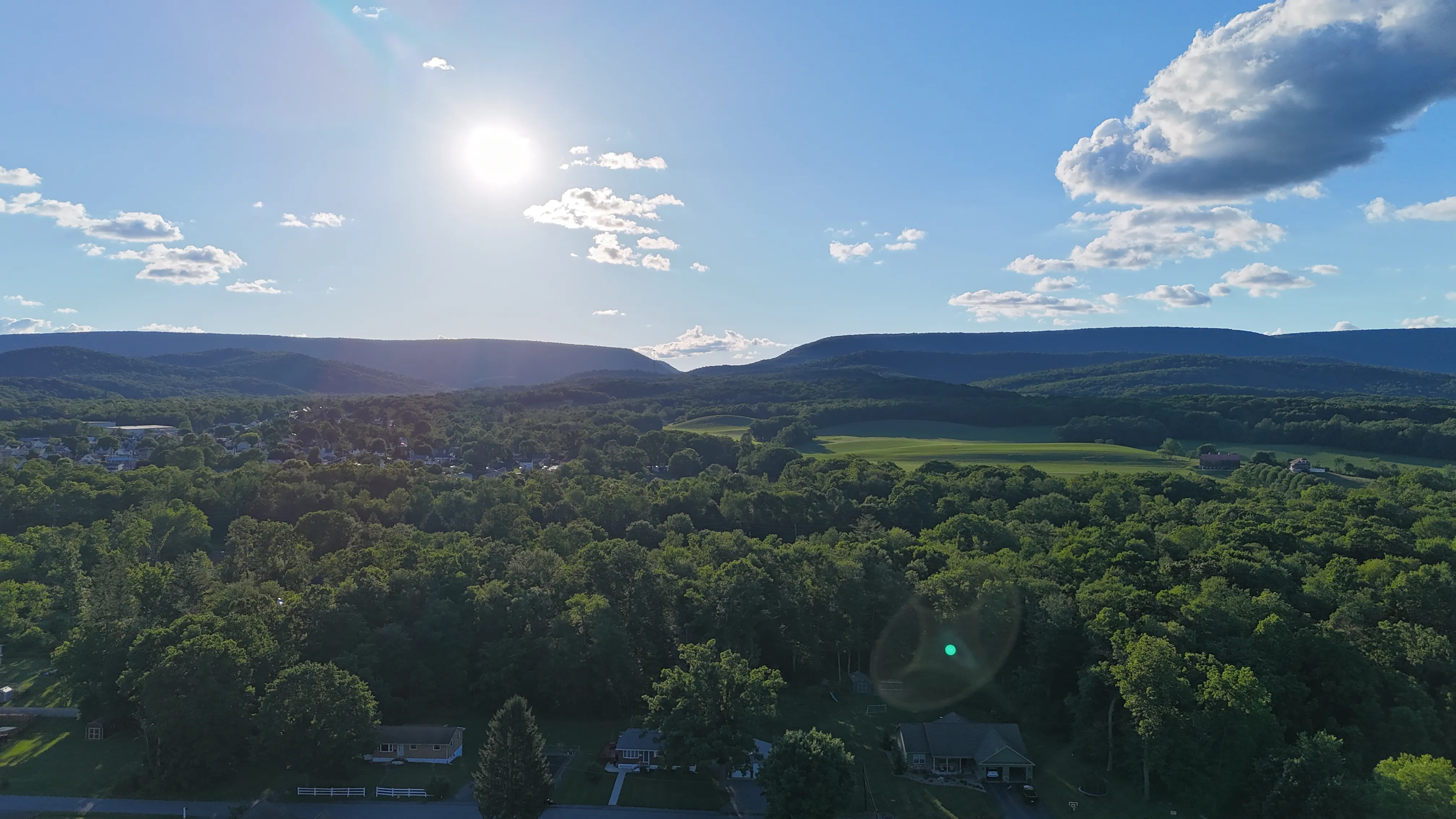 Evening light across the wooded ridges and farmland around Bellwood, Pennsylvania, seen from the air.